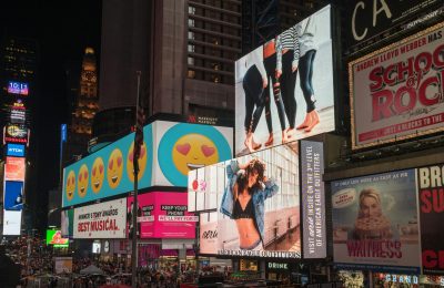 Colorful billboards light up New York City's iconic Times Square at night, with vibrant ads and bustling crowds.